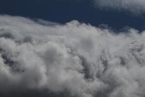 clouds landskap, mulen väder ovan mörk blå himmel. storm moln flytande i en regnig tråkig dag med naturlig ljus. vit och grå naturskön miljö bakgrund. natur se. foto