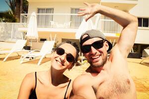 Lycklig reser par framställning selfie i hotell sola. sommar strand högtider. romantisk humör. eleganta solglasögon. Lycklig skrattande emotionell ansikten hipster multiracial. cypern Semester foto