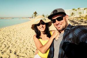 Lycklig raser par tar selfie på sommar semester - trendig man och kvinna har roligt på cypern nissi strand. vänskap och högtider begrepp med kille och flicka njuter sommar foto