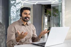 en glad kund service representativ samtal använder sig av headsetet i en modern kontor miljö, bistå klienter med expertis och en leende foto
