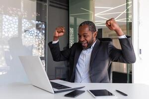 mogna erfaren affärsman fira seger Framgång på arbetsplats, chef inuti kontor Lycklig med finansiell resultat prestation mottagen uppkopplad underrättelse vinna meddelande, innehav händer upp. foto