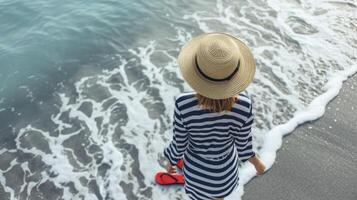 en Marin blå och vit randig knappen ner skjorta bärs som en strand täckning parade med röd Flip flops och en sugrör fedora de slutlig beachy nautisk se foto