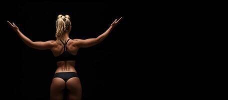 atletisk blond flicka i sporter underkläder på en svart bakgrund, tillbaka se baner foto