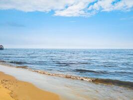 fotografi av vågor på de strand med en klar himmel för en sommar bakgrund foto