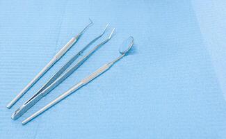 tandläkarens verktyg på ljus blå bakgrund foto