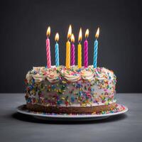 färgrik födelsedag kaka med strössel och ljus på en blå grå bakgrund. foto