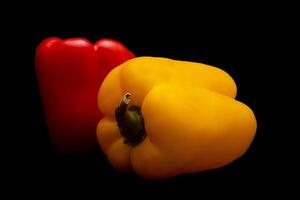 röd och gul peppar i svart bakgrund foto