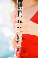 flicka musiker spelar de klarinett. beskuren. ansiktslös foto