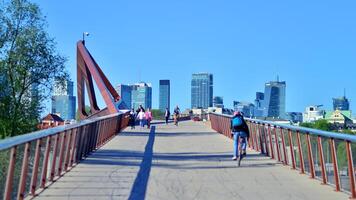 Warszawa, polen. 11 april 2024. bro över de vistula flod avsedd endast för fotgängare och cyklister. i de bakgrund, en panorama av de stad med skyskrapor. foto