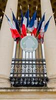 franska tricolor flaggor smycka en parisian byggnader balkong, symboliserar bastille dag stolthet i paris foto