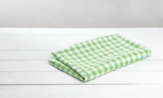 grön rutig bordsduk på vit tabell bakgrund foto
