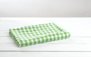 grön vikta bordsduk på vit tabell bakgrund för produkt montage foto