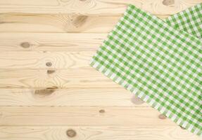 grön rutig bordsduk på trä- tabell foto