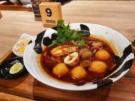 ett av de signatur Ramen från en Ramen specialist restaurang. skaldjur tom yum Ramen. foto