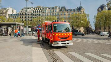 röd franska brand motor svara till ett nödsituation i paris, Frankrike, med fotgängare och traditionell arkitektur i bakgrund, april 14, 2024, urban säkerhet begrepp foto