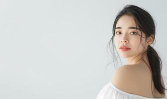 elegant öst asiatisk kvinna med röd läppstift och off-shoulder topp foto