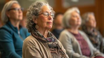 mjuk musik spelar i de bakgrund som pensionärer av olika bakgrunder och åldrar delta i en mindfulness verkstad guidad förbi ett erfaren instruktör foto