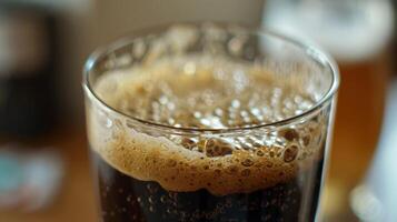 en närbild av en glas fylld med en mörk skummig flytande de resultat av en framgångsrik hembryggt rot öl recept foto