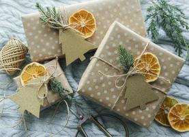 juldekorativa hemgjorda presentförpackningar inslagna i brunt kraftpapper foto