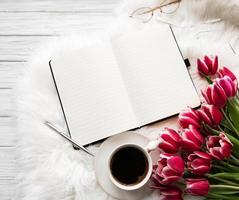 anteckningsbok, kopp kaffe och rosa tulpaner