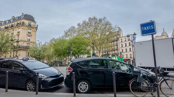 taxi stå i en livliga europeisk stad med parkerad bilar, traditionell arkitektur, och vår lövverk, idealisk för urban transport och resa teman foto