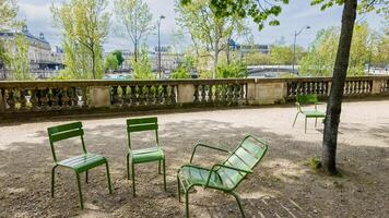 lugn scen med tömma grön metall stolar på parisian parkera väg, springtime fritid och avslappning begrepp, relaterad till europeisk högtider och turism foto