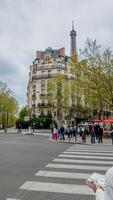 parisian gata scen med olika fotgängare nära eiffel torn på en molnig vår dag, perfekt för resa och kultur teman, paris, Frankrike, april 14, 2024 foto