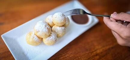 hemlagad dutch poffertjes mini pannkakor med glasyr pulveriserad socker och choklad fyllningar med ytterligare choklad sås foto