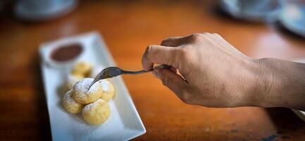 hemlagad dutch poffertjes mini pannkakor med glasyr pulveriserad socker och choklad fyllningar med ytterligare choklad sås foto