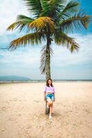 brasiliansk kvinna Framställ på en palmträd på de strand av santos, Brasilien. foto