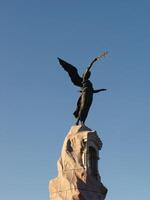 brons monument av sjöjungfru med en korsa på sten i kadriorg parkera i Tallinn, estland. skulptur av rusalka till de Marin och de död- sjömän foto