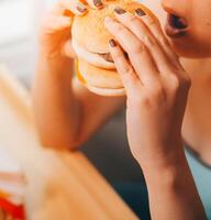 binge äter oordning begrepp med kvinna äter snabb mat hamburgare, sparken kyckling , munkar och desserter foto