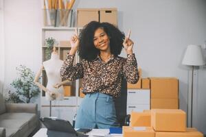 startup sme småföretag entreprenör av frilansande asiatisk kvinna som använder en bärbar dator med låda glad framgång asiatisk kvinna hennes hand lyfter upp onlinemarknadsföring förpackningslåda och leverans sme idékoncept foto