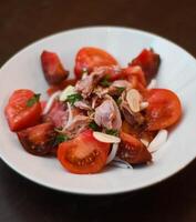tomat och tonfisk sallad, med lök. gourmet maträtt med kvalitet tomater. foto