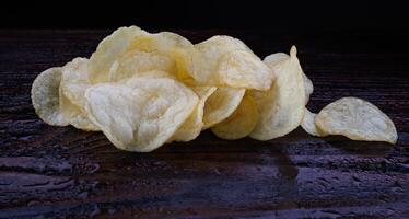 potatis pommes frites på en mörk bakgrund. pommes frites på en trä- styrelse foto