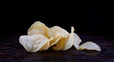 potatis pommes frites på en mörk bakgrund. pommes frites på en trä- styrelse foto