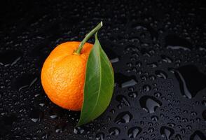 mogen saftig mandarin på en svart bakgrund med vatten droppar. foto