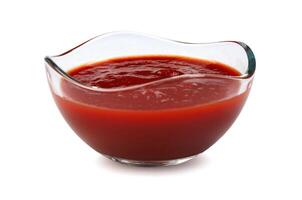 ketchup i en glas kopp isolerat på en vit bakgrund. tomat sås . foto