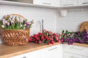 en stor siffra av tulpaner av annorlunda färger lögner i de kök i de handfat. blommor i en korg foto