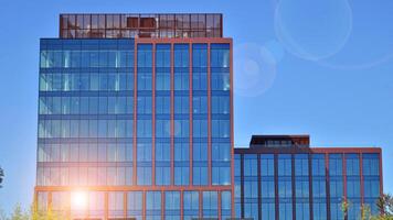 glas byggnad med transparent Fasad av de byggnad och blå himmel. strukturell glas vägg reflekterande blå himmel. foto