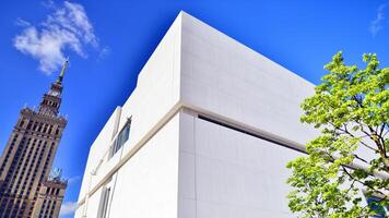 modern vit betong byggnad väggar mot blå himmel. eco arkitektur. grön träd och betong kontor byggnad. de harmoni av natur och modernitet. foto