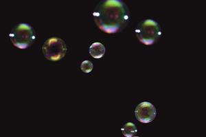 transparent färgglada bubblor tvål mönster överlägg abstrakta partiklar stänk av vatten på svart. foto