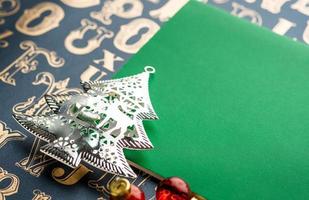 julgransdekoration med grön anteckningsbok på gamla typmönster foto
