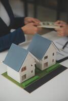 företag signering en kontrakt köpa - sälja hus, försäkring ombud analyserar handla om Hem investering lån verklig egendom begrepp. foto