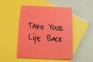 begrepp av ta din liv tillbaka skriva på klibbig anteckningar isolerat på trä- tabell. foto