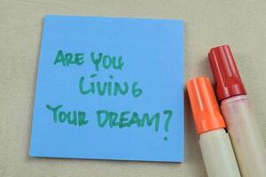 begrepp av är du levande din dröm skriva på klibbig anteckningar isolerat på trä- tabell. foto