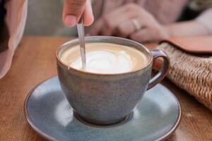 person hand rör om kaffe med sked. foto