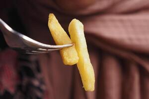 närbild av gaffel plocka franska frites foto