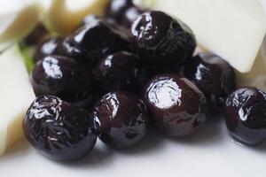samling av svart oliver med ost på en tallrik . foto