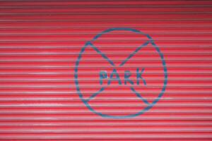 en röd garage dörr med de ord Nej parkera målad på den foto